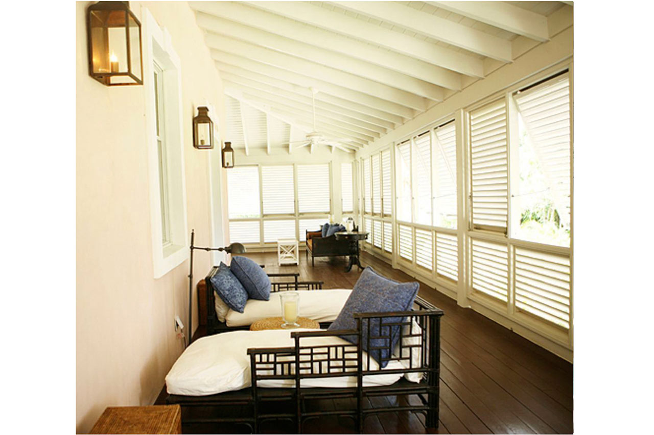 second floor porch of a Traditional Bahamian style louvered house designed by Maria de la Guardia & Teofilo Victoria of DLGV Architects & Urbanists